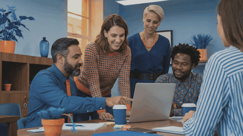 work colleagues collaborating at a desk with a laptop computer